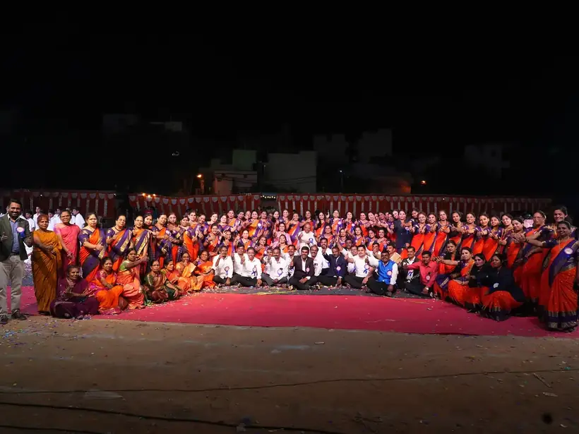 Large group of school staff and students gathered outdoors in traditional dress
