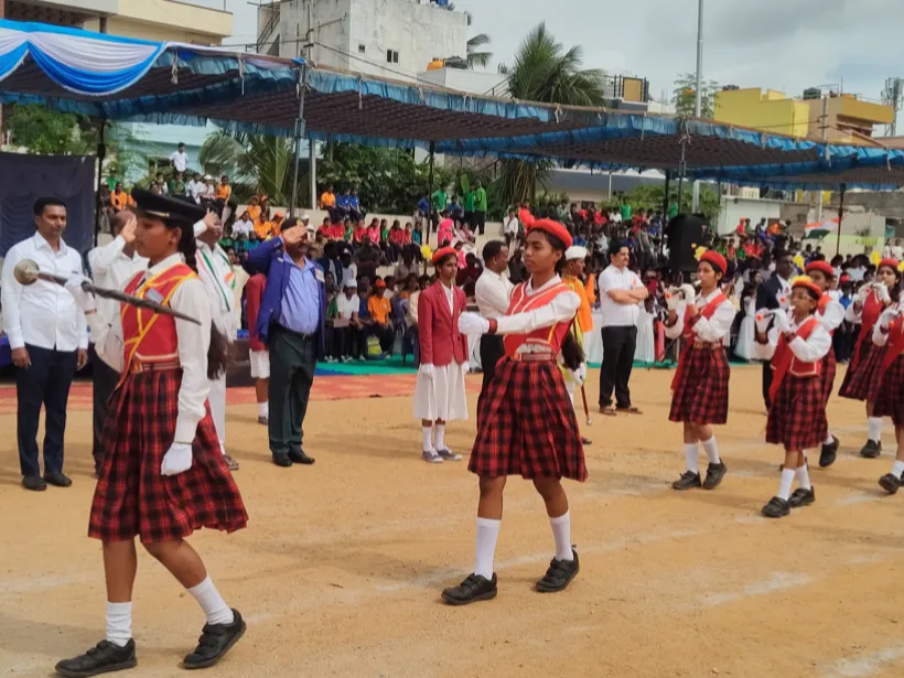 Primary school girls in tartan skirts marching past the saluting dais during the Independence Day parade