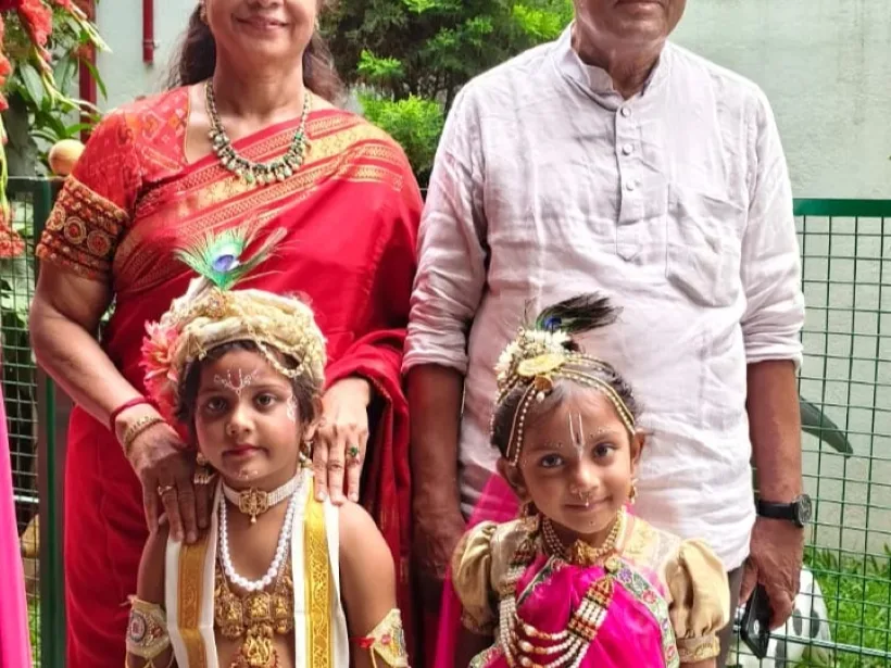 Two children dressed as Krishna and Radha for Krishna Janmashtami, with two senior school staff members