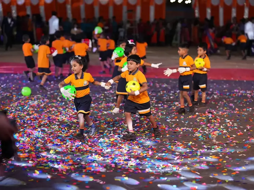 Primary children in sports uniform performing a mass ball display