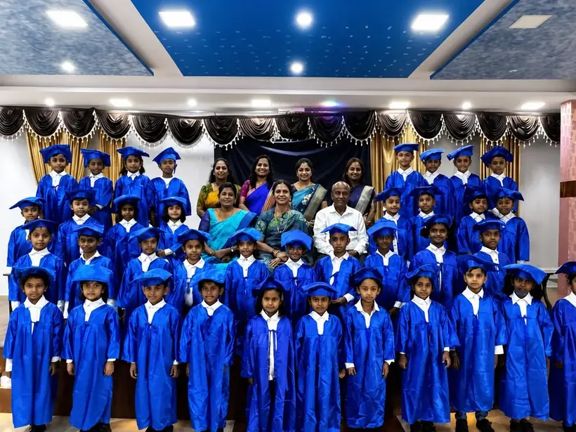 Nursery Wing children in blue graduation gowns and caps with their teachers