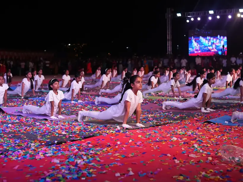 Large group of students performing a coordinated yoga display on stage