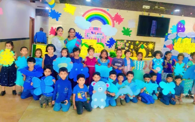 Two teachers in blue and purple sarees standing with students dressed in blue for Colour’s Day at St. Lawrence