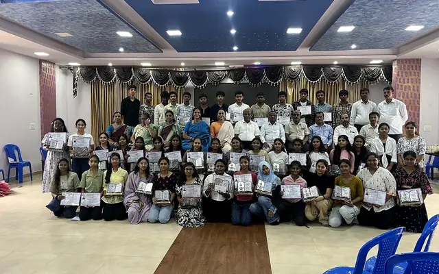 Large group of students holding certificates in the school auditorium at the felicitation ceremony