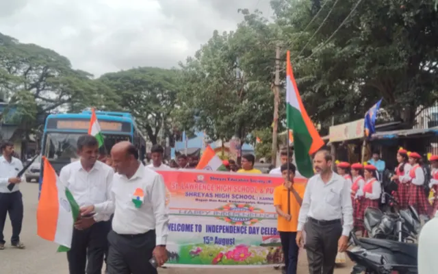 Students and staff carrying national flags and a banner on an Independence Day awareness rally through Kamakshipalya
