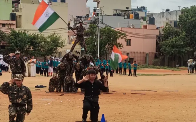 Cadets in camouflage uniform forming a human pyramid holding the national flag at the top