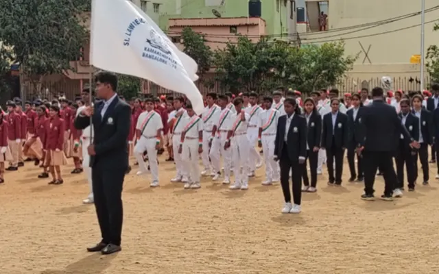 Senior students in blazers carrying the St. Lawrence school flag at the head of their contingent