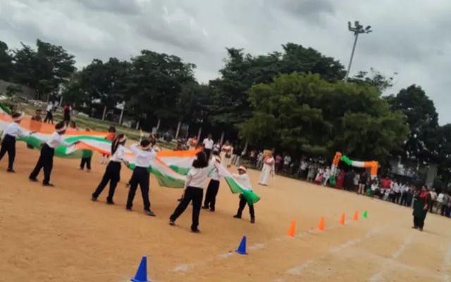 Students unfurling a giant national flag across the school ground during the Independence Day display