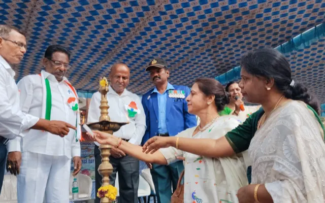 School management welcoming the Independence Day guests beside the lit ceremonial lamp