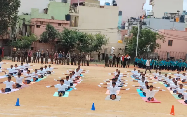 Rows of students performing a coordinated yoga demonstration on mats on the school ground