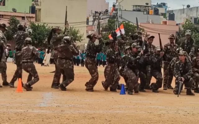 Cadets in camouflage uniform performing an armed-forces style mock drill during the Independence Day display