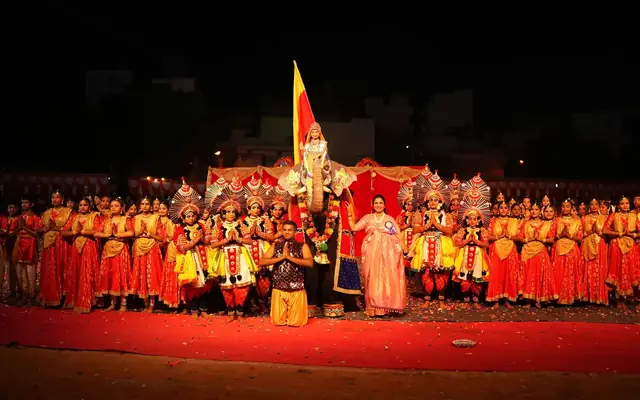 Students in formation holding the Karnataka state flag during a celebration