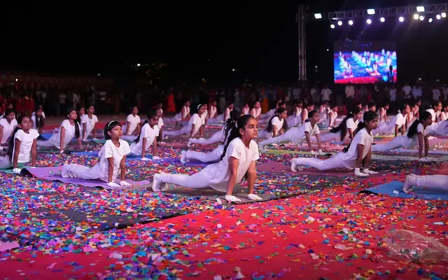 Large group of students performing a coordinated yoga display on stage