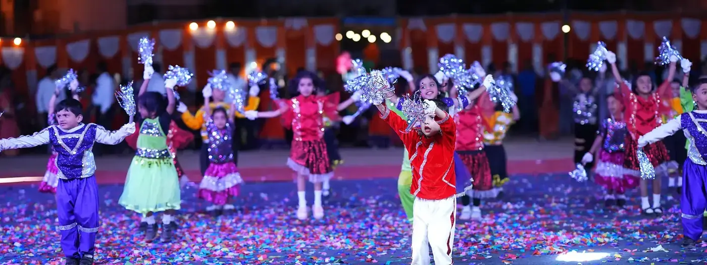Young children performing a group display on a brightly lit stage