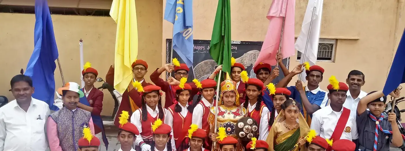 Bharat Scouts and Guides students in uniform holding troop flags outdoors